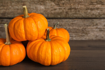 Fresh ripe pumpkins on wooden table, space for text