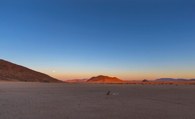 Full moon at sunset in Namib Desert