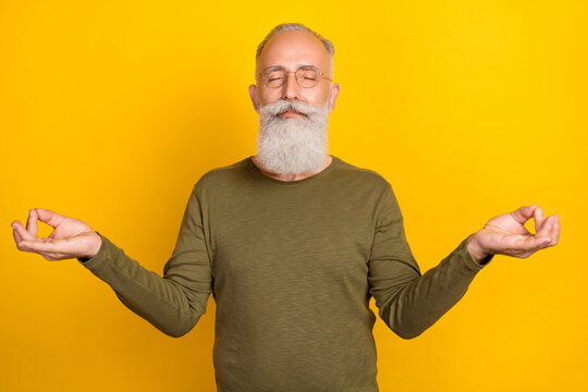 Photo of relax elder white beard man closed eyes wear eyewear green sweater isolated on yellow color background