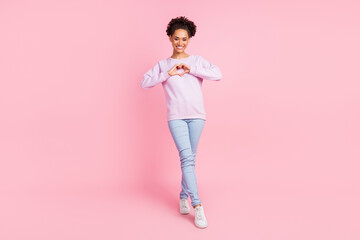 Full size photo of young pretty lovely smiling african woman showing heart symbol isolated on pink...