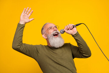 Photo of funky old white beard man sing in mic wear eyewear green sweater isolated on yellow color background - obrazy, fototapety, plakaty