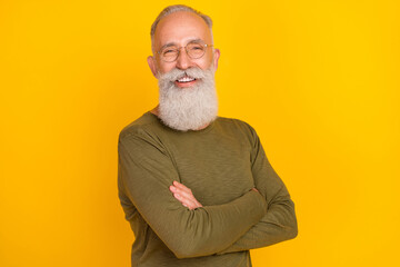 Photo of positive cheerful self-assured old man folded arm wear glasses green shirt isolated yellow...