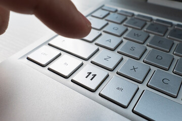 Close up of finger on keyboard button with number 11