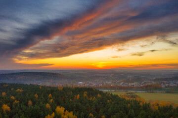 Beautiful sunset over the autumnal forest in Rotmanka, Poland