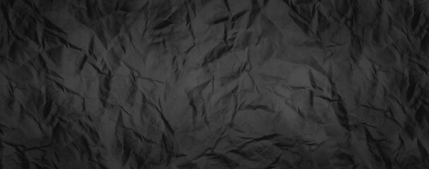 Rugged wrinkled crumpled dark black paper texture background