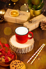 Red cup of milk and cookies for Santa Claus. Christmas treat for Santa vertical photo