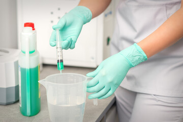 The beautician uses a syringe to add disinfectant to the water. Sterilization of tools