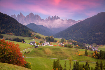 Autumn in Alps. Beautiful St. Magdalena village with magical Dolomites mountains in a gorgeous Val di Funes valley,  South Tyrol, Italian Alps at autumn sunset.