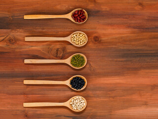 Natural organic beans and various legume as cooking ingredients prepared and measured for mixing compound by luxury wooden spoon as protein nutrient recipe for vegan nourishment food