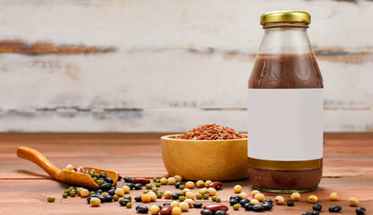 Sweet supplementary fruit drink for health nourishment served with kitchen bowl of brown rice and wooden spoon of organic beans