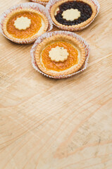 apricot and cherry jam shortcrust pastry in a paper backing cup on a rustic wooden background
