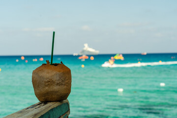 Cocktail in peeled coconut near the crystal blue sea