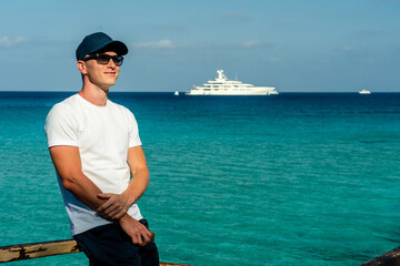 Man in sunglasses near the crystal blue sea