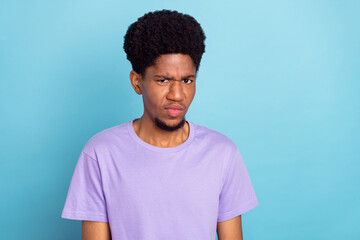 Photo of sad millennial brunet guy wear violet t-shirt isolated on blue color background