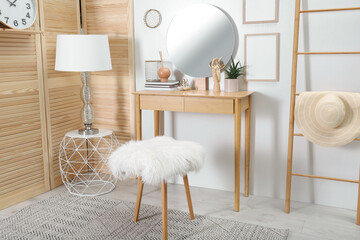 Modern wooden dressing table with mirror and stool in room