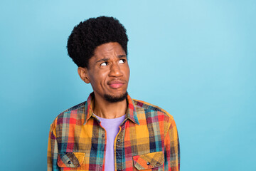 Photo of sad young brunet guy look empty space wear yellow shirt isolated on blue color background