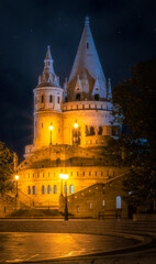 Fototapeta na wymiar The Fisherman's Bastion in floodlight under the starry night sky in Hungary, Budapest