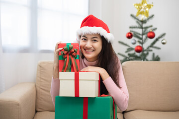 Happy beautiful Asian woman celebrate with stacking many present gift box in christmas party. Cute girl in christmas holiday holding gift box decorated with ribbon and bow. Happy new year festival.