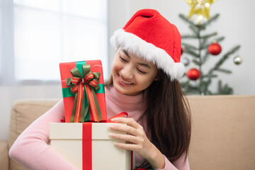 Obraz na płótnie Canvas Happy beautiful Asian woman celebrate with stacking many present gift box in christmas party. Cute girl in christmas holiday holding gift box decorated with ribbon and bow. Happy new year festival.