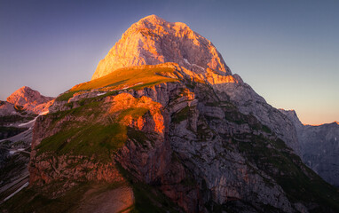 Slovenian mountain peak on Mangart lit by sunlight during sunset