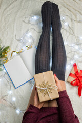 girl in stockings and sweater holding a gift box gift box
