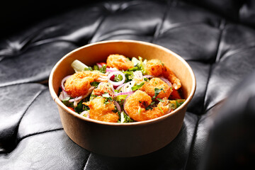 Fried prawns on a green salad. Takeaway, diet box.
Appetizing ready-to-go dish served in a disposable box. Culinary photography. Food background.