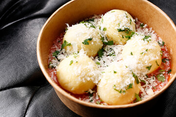 Gnocchi di patate, potato dumplings with tomato sauce, and Parmesan cheese. Takeaway, diet box.
Appetizing ready-to-go dish served in a disposable box. Culinary photography. Food background.