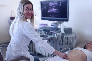 The ultrasound doctor examines the woman's abdominal cavity - obrazy, fototapety, plakaty