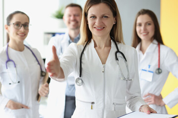 Fototapeta premium Friendly female doctor stretches out her hand