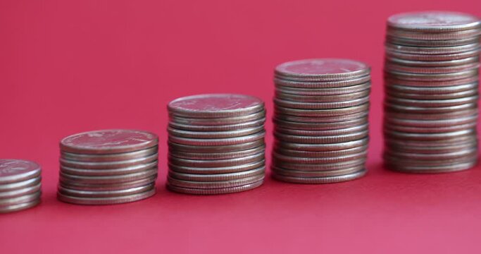 Stacks of coins ascending with piggy bank on red background 4k movie