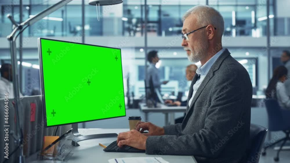 Poster Diverse Modern Office: Senior Caucasian IT Technician Using Desktop Computer with Green Chroma Key Screen. Engineer Administrator Work on e-Commerce Development, Project Marketing, Big Data Analysis