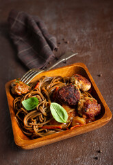 Plate soba with fried cutlets and sauce on a table.