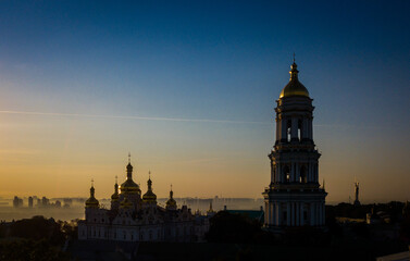 Fototapeta premium Beautiful aerial view of Pechersk Lavra in Kyiv at sunrise. A UNESCO world heritage site in Ukraine. View from drone. Space for text. 