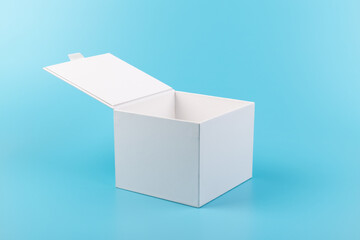 Opened white paper cube box on a blue background.