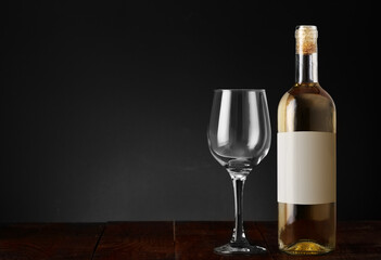 wine bottle with empty goblet on wooden table