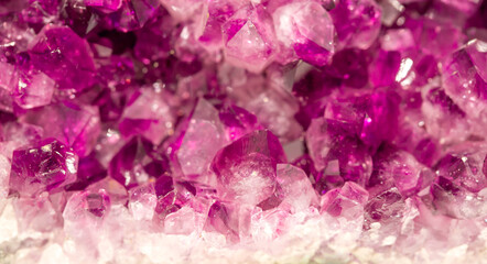 Fototapeta premium Amethyst pink crystals. Gems. Mineral crystals in the natural environment. Texture of precious and semiprecious stones. Seamless background with copy space colored shiny surface of precious stones.