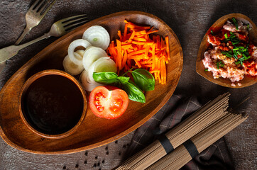 raw soba and fresh vegetables . raw vegetables and sauce on plate