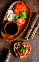 raw soba and fresh vegetables . raw vegetables and sauce on plate