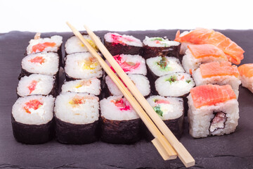 on a white background. the black stone on it is pieces of seafood, sushi. close-up. Asian food