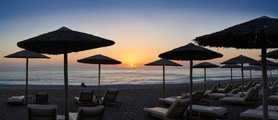 Schilderijen op glas Beach Umbrellas with sunset © gemphotography