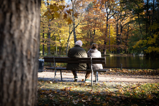 2 Rentner sitzen gemeinsam im Herbst auf einer Parkbank