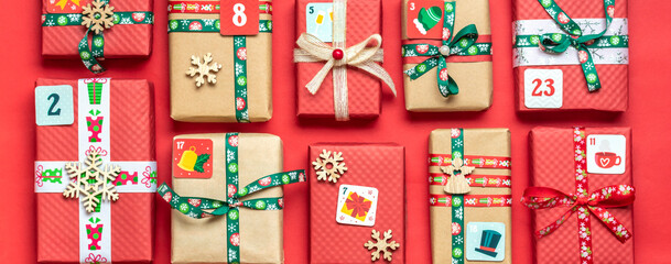 Handmade wrapped red, green gift boxes decorated with ribbons, snowflakes and numbers, Christmas decorations and decor on table Xmas advent calendar concept Top view Flat lay Holiday card Banner	