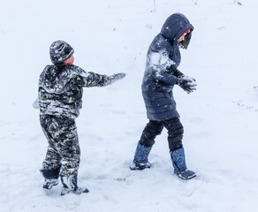 Fototapeta na wymiar Boy and girl play in the snow
