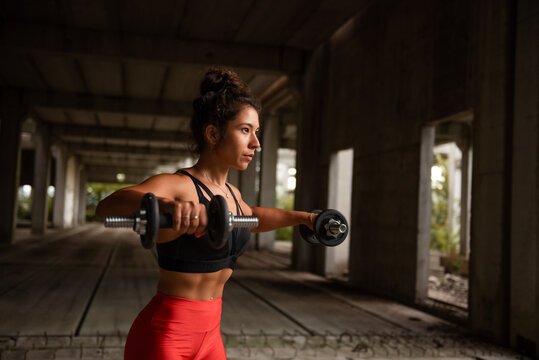 Fit woman training with weights outdoor