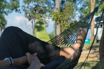 young caucasian man swinging in a hammock in a Monjai Chiangmai of a weekend morning.