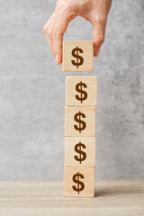 Businessman hand holding wooden blocks with the American Dollar symbol. Money, cash, currency and...