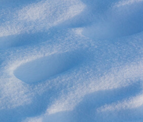 Snow on the ground in the rays of sunset in winter.