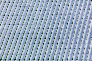 Snow on the roof of the house in winter.