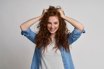 Fototapeta premium Redhead woman with hands in hair