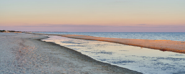 Amazing peaceful beach landscape, beautiful sunset purple sky over calm water